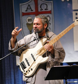 Franciscan Friars of the Renewal Father Stan Fortuna of Bronx, N.Y., performs a song during the fourth annual Indiana Catholic Men’s Conference on Oct. 17 at the Indiana Convention Center in Indianapolis. He urged the 950 participants to “man up” and accept their responsibilities as Christians. (Photo by Mary Ann Wyand)