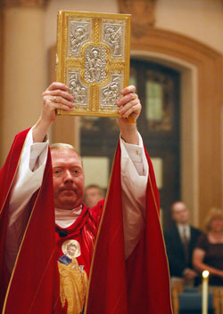 Father Patrick Beidelman processes with a Book of the Gospels during a June 29, 2007, Mass at SS. Peter and Paul Cathedral in Indianapolis that celebrated the centennial of the dedication of the cathedral. As archdiocesan director of liturgy, Father Beidelman has been busy for two years helping to prepare Catholics across central and southern Indiana for the implementation of the new translation of the Mass that takes place on Nov. 26-27. (File photo by Mary Ann Garber)