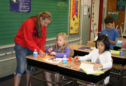 St. Jude parishioner Brittany Fahringer, left, a volunteer aide in the third-grade religious education class, helps Lauren Pfeiffer, center, and Sophie McKinney, right, with a class lesson on Sept. 9. (Submitted photos)