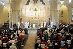 Conventual Franciscan Father Edmund Goldbach, pastor of St. Benedict Parish in Terre Haute, proclaims the Gospel to a full church on March 19 during the Mass for the Solemnity of St. Joseph at St. Joseph University Parish in Terre Haute. (Submitted photo by Amy Miranda)