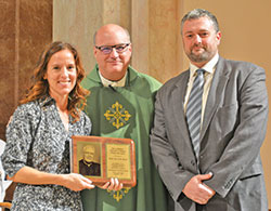 Cara and Josh Bach pose with Msgr. William F. Stumpf, archdiocesan vicar general, after receiving the Office of Pro-Life and Family Life’s annual Archbishop Edward T. O’Meara Pro-Life Award at SS. Peter and Paul Cathedral on Oct. 1. (Photo by Natalie Hoefer)