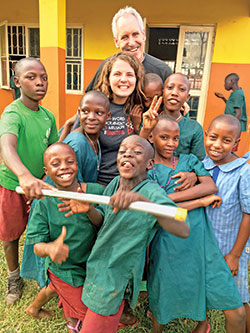 Father Tom Kovatch, top, and Jenna Dedek, center, both of St. Charles Borromeo Parish in Bloomington, pose with the students at St. Jerome Primary School in Kapeeka, Uganda, during a mission trip on June 10, 2016. The parish makes regular trips to visit the school. (Submitted photo)