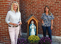 Carmie Klein, left, and Amanda DeRoche, both members of St. John the Evangelist Parish in Indianapolis, pose on Aug. 24 outside the parish church. Klein helped form DeRoche as a missionary disciple through video chats they had online earlier this year during the coronavirus quarantine. (Photo by Sean Gallagher)