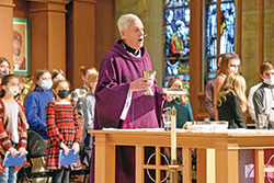 Father Robert Sims, pastor of Immaculate Heart of Mary Parish in Indianapolis, prays the eucharistic prayer during a school Mass on Dec. 17, 2021, in his parish’s church. The day was the 50th anniversary of his ordination as a priest. (Photo by Sean Gallagher)