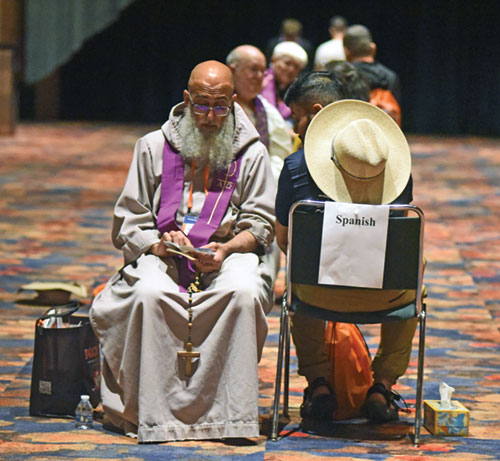 A priest hears a confession on July 17 in the Indiana Convention Center during the National Eucharistic Congress in Indianapolis. (File photo by Sean Gallagher)