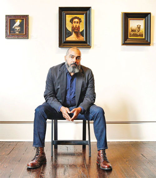 Jay Parnell poses in front of paintings he has created. After being received into the full communion of the Church in 2020, Jay has sought to use his artistic talents to create sacred art to draw others closer to God and the Church. He is a member of Our Lady of the Most Holy Rosary Parish in Indianapolis. (Submitted photo)